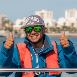 a man sitting next to a body of water
