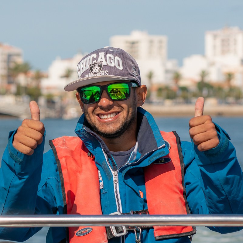 a man sitting next to a body of water