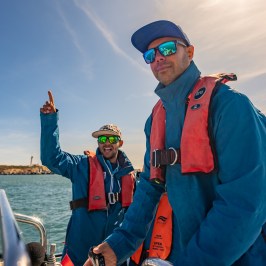 a man standing next to a body of water