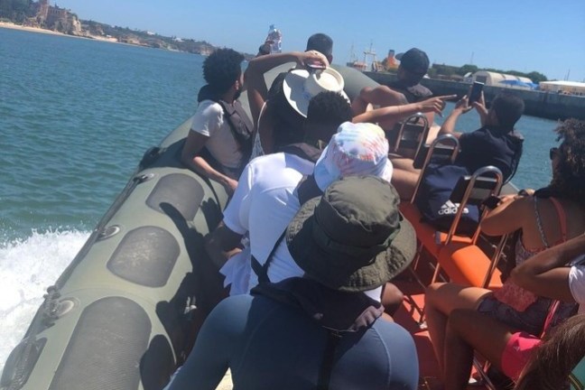 a group of people standing next to a body of water