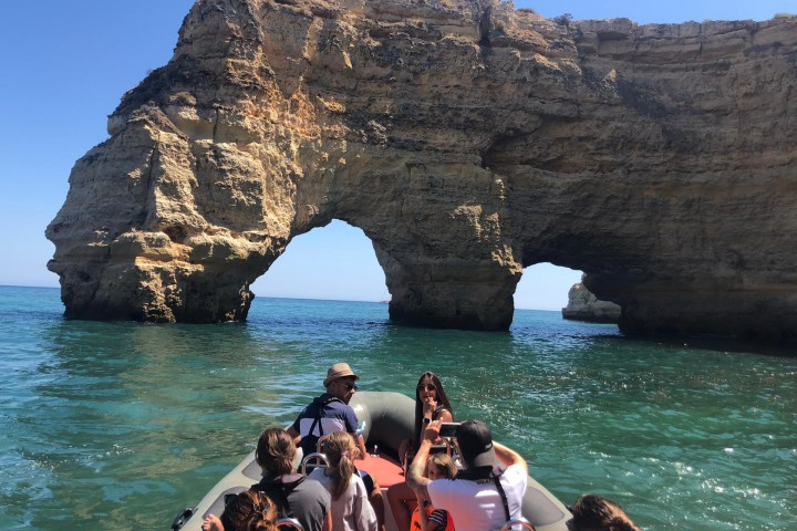 a group of people sitting on a rock next to a body of water